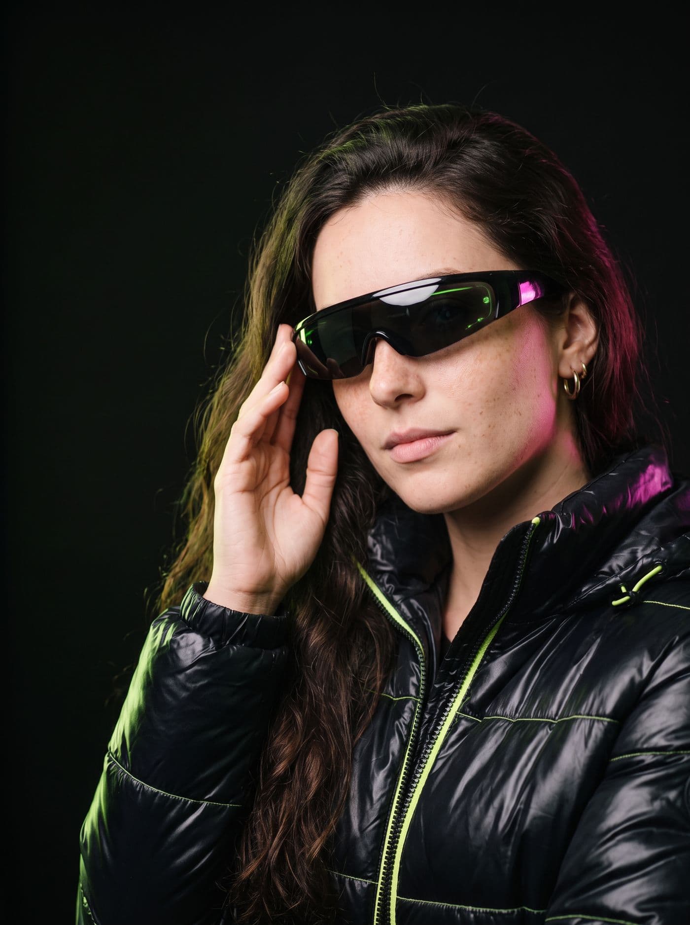 Mulher ajustando um óculos inteligente de lente única, com luz verde por trás